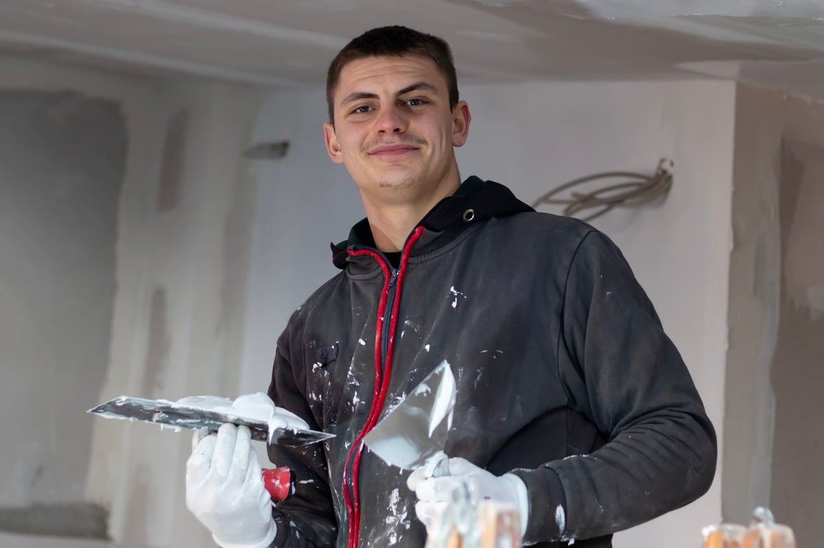 Builder spackling and finishing a ceiling — professional drywall finishing